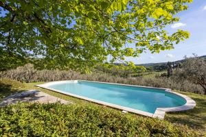 una piscina en medio de un campo con árboles en Isola del Pittore casa indipendente in Villa Storica, en Grassina