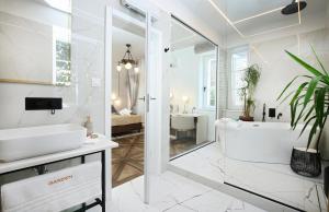 Baño blanco con bañera y lavamanos en Garden Luxury Room, en Split