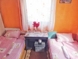 um quarto com duas camas e uma mesa com flores em VIRMAL em Foca