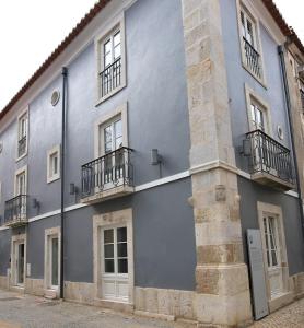 a blue building with balconies on the side of it at CASA DAS QUATRO CABEÇAS in Setúbal
