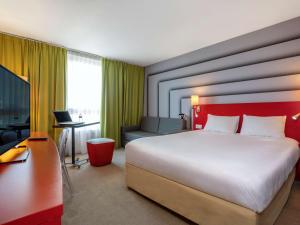 una camera d'albergo con un grande letto e una scrivania di ibis Styles Avignon Sud ad Avignone
