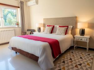 a bedroom with a large bed with a red blanket at Naturena Agro-Turismo in Durrães