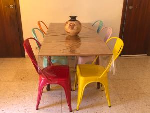 a wooden table with colorful chairs and a vase on it at Casa El Castellet en Polop. in Polop