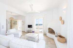 a white living room with white furniture and a fireplace at Irene's House in Aliki in Aliki