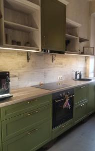 a kitchen with green cabinets and an oven at Vintage Rooms in Kuldīga +32 photos