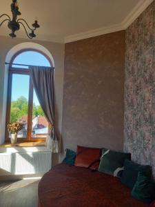a bedroom with a bed and a window at Vintage Rooms in Kuldīga