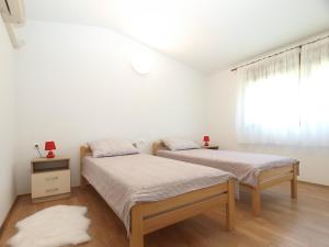 two beds in a white room with a window at House Mario 1931 in Banjole