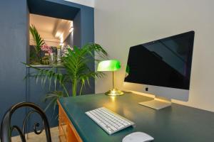 escritorio con monitor de ordenador y teclado y ratón en Hotel Italia en Turín