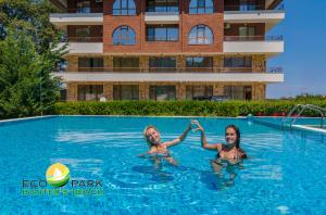 dos chicas jugando en la piscina de un hotel en Complex Hunter's Beach, en Shkorpilovtsi