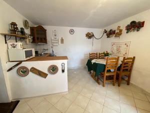 eine Küche und ein Esszimmer mit einem Tisch und einer Mikrowelle in der Unterkunft Kolokán vendégház in Sarud