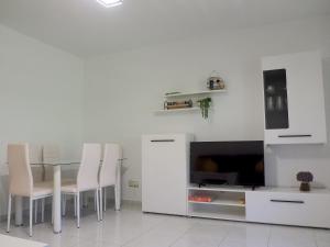 Apartamento Turístico Duero Niño في مولينوس ديه دويرو: غرفة طعام مع طاولة وكراسي وتلفزيون