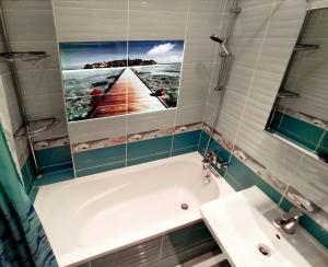 a bathroom with a bath tub and a sink at Apartments IRIS in Karlovy Vary