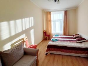 a bedroom with a bed and a couch and a window at Apartments IRIS in Karlovy Vary