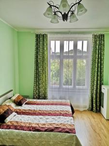 Un dormitorio con una cama con paredes verdes y una ventana en Apartments IRIS, en Karlovy Vary
