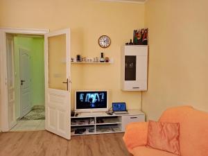 una sala de estar con TV en un armario y una puerta en Apartments IRIS, en Karlovy Vary