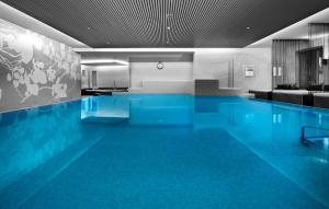 una gran piscina de agua azul en un edificio en Giardino Bed & Breakfast en Silvaplana