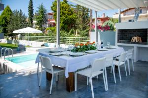 イラクリトサにあるVilla Kallistiの白いテーブルと椅子、プール付きのパティオ