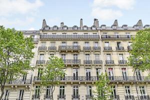 um edifício de apartamentos em Paris com árvores em frente em CMG Malesherbes em Paris
