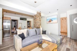 a living room with a couch and a table at Black Rocks Family, Luxury Seafront Beach Maisonette in Agios Gordios