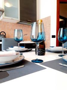 a table with three wine glasses and a bottle of wine at Clizia Apartment in Alghero
