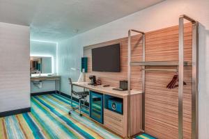 a hotel room with a desk and a tv at Casa Via Mar Inn, Ascend Hotel Collection in Port Hueneme
