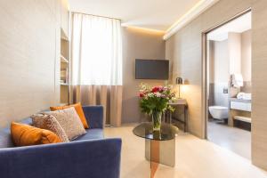 a living room with a blue couch and a table with flowers at Orazio Palace Hotel in Rome