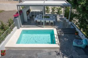 an overhead view of a pool with a table and chairs at Villa Kallisti in Iraklitsa