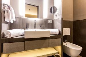a bathroom with a sink and a toilet and a mirror at Orazio Palace Hotel in Rome