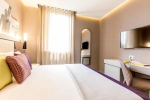 um quarto de hotel com uma cama grande e uma secretária em Orazio Palace Hotel em Roma