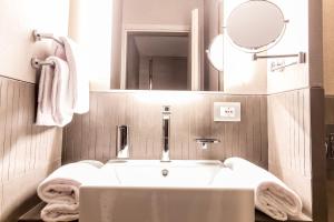 a bathroom with a white tub and a mirror at Orazio Palace Hotel in Rome