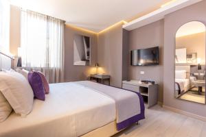 ein Hotelzimmer mit einem großen Bett und einem Spiegel in der Unterkunft Orazio Palace Hotel in Rom