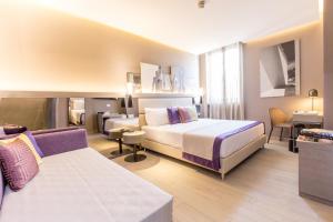 a hotel room with two beds and a couch at Orazio Palace Hotel in Rome