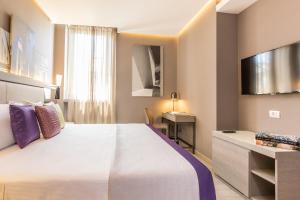 a hotel room with a large bed and a television at Orazio Palace Hotel in Rome