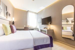 a hotel room with a large bed and a mirror at Orazio Palace Hotel in Rome