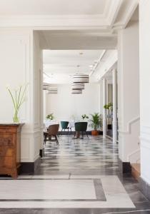 un couloir avec des chaises et des tables dans un bâtiment dans l'établissement Gran hotel Brillante, à San Esteban de Pravia