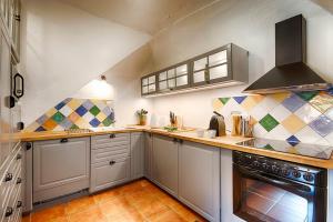 a kitchen with white cabinets and a stove at Can Cruanyes in Sales del Llierca