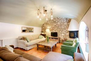ein Wohnzimmer mit einem Sofa und einem Tisch in der Unterkunft Can Cruanyes in Sales del Llierca
