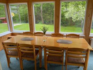 Un comedor con mesa y sillas y ventanas. en Chata u potoka 124, en Černý Důl