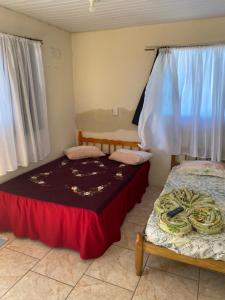 a bedroom with two beds and a window at Pousada Cantinho Azul in Passo de Torres