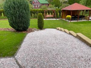 un jardín con un camino de grava y un cenador en Chata u potoka 124, en Černý Důl 5 fotos más