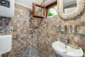un baño con lavabo y espejo en Apartman Glicinija, en Herceg-Novi