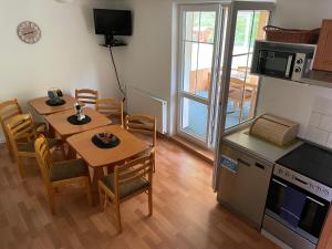 Una cocina y un comedor con mesa y sillas. en Chata u potoka 124, en Černý Důl