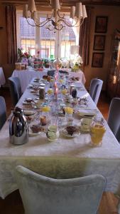 a long table with plates and dishes on it at La Maison de juliette in Saint-Hippolyte