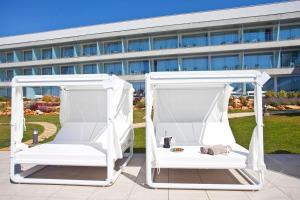 two white swing beds in front of a building at Seth 55 Santo Tomas in Santo Tomás