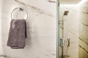 a towel hanging on a towel rack in a bathroom at Black Rocks Family, Luxury Seafront Beach Maisonette in Agios Gordios +49 photos