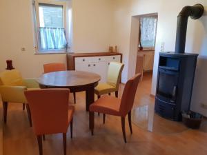 a dining room with a table and a wood stove at Sunshine Westernranch in Kasendorf