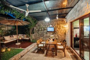 un patio con una mesa de madera con sillas y una sombrilla en Apartman Glicinija, en Herceg-Novi 52 fotos más