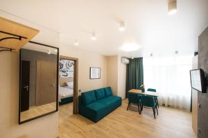 een woonkamer met een blauwe bank en een tafel bij ORION apartments in Kiev