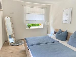 een slaapkamer met een bed, een spiegel en een raam bij Ferienwohnung Flur 34 in Adenau