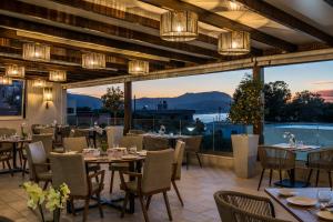 a restaurant with tables and chairs and a large window at Sun and Sea Plus Resort in Plaka